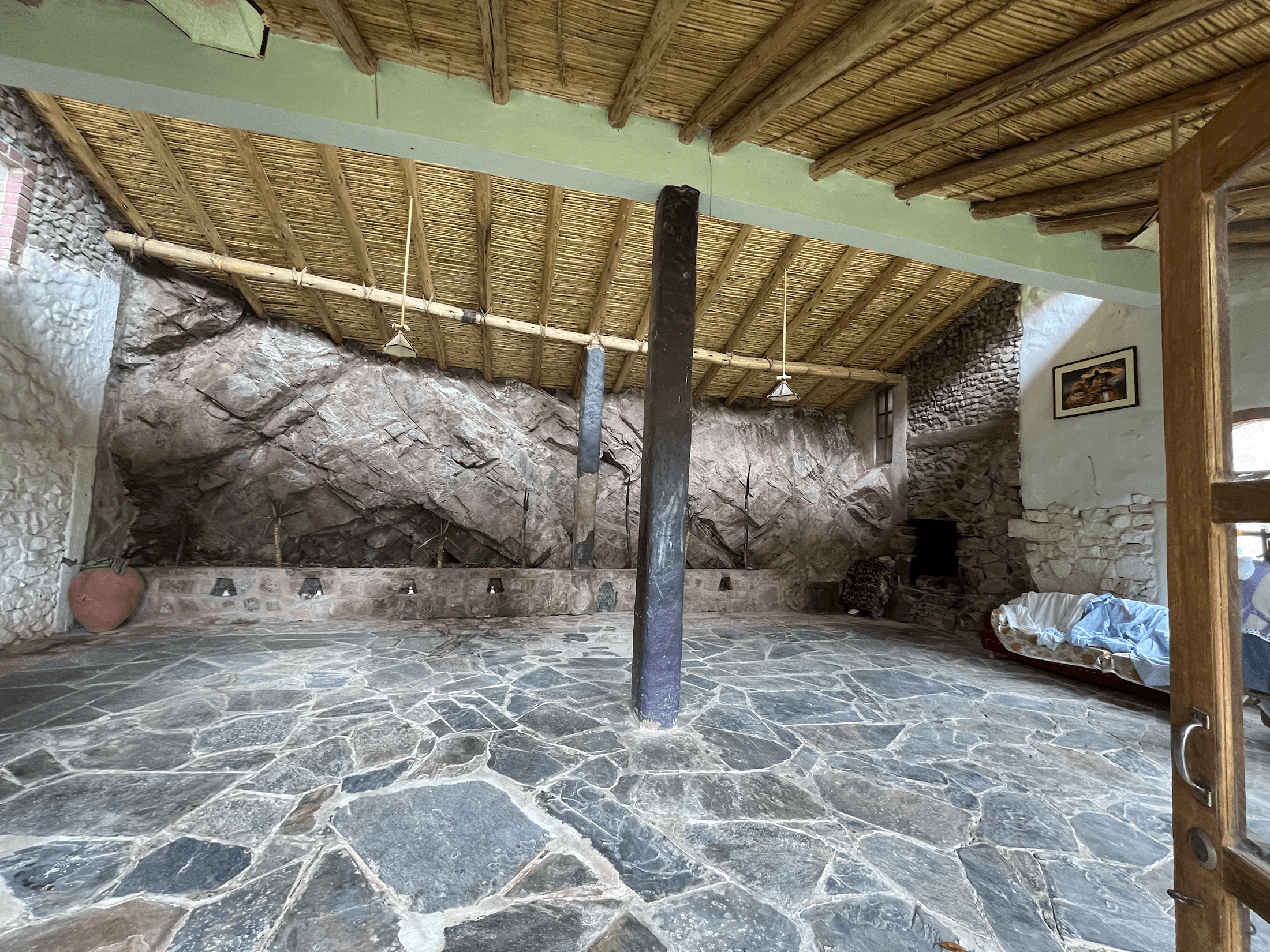 Cave-like ceremonial hall at El Molle with stone floor and natural rock wall