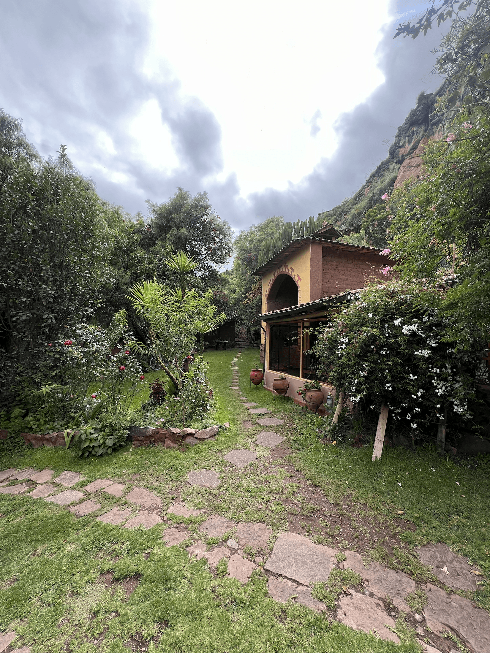 Garden path at El Molle leading toward an adobe house surrounded by plants
