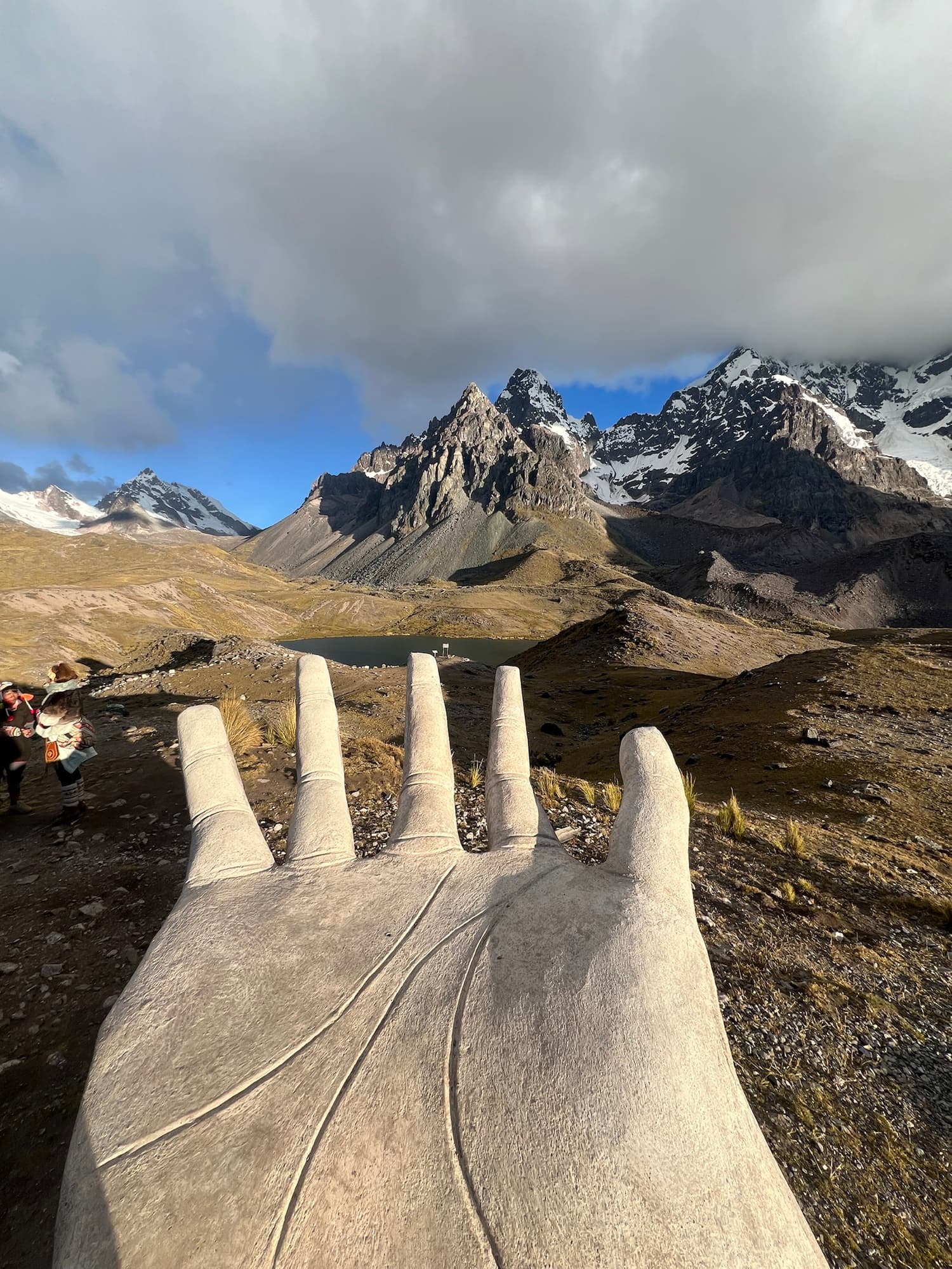 Large stone hand viewpoint facing snowy Ausangate peaks