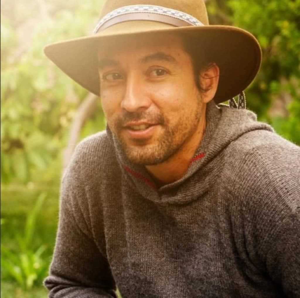 Octavio Davila Solari outdoors wearing a brown hat with soft greenery in the background